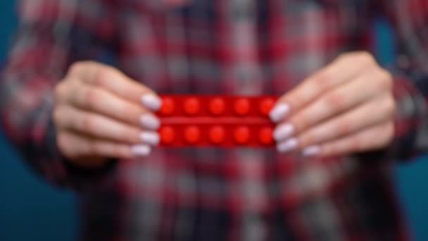 mulher apresentando uma mão de pílulas embrulhadas em papel alumínio
 - Filmagem, Vídeo