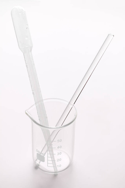 un vaso de precipitados vacío con pipeta de plástico y una varilla de vidrio
 - Foto, Imagen