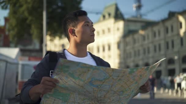 Real time portrait shot of a young Asian man looking at a map. Moscow is the capital and the most populous city in Russia. - 映像、動画