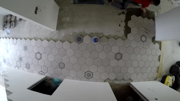 Professional worker laying hexagon stone mass tiles on floor. Timelapse - Footage, Video