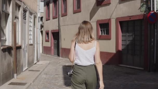 Young Woman Is Walking in European City, View from Back - Materiał filmowy, wideo