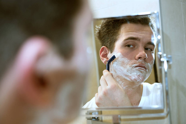 young man shaving - 写真・画像