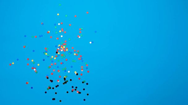 fényes sokszínű kerek konfetti szétszórva a kék háttér - Fotó, kép