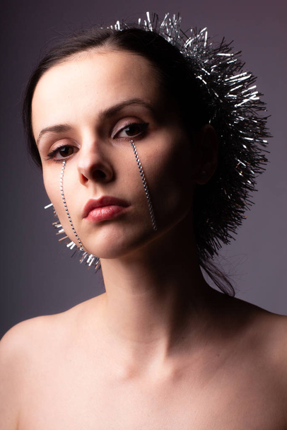 portrait of a girl with bare shoulders, hairstyle with tinsel, on the face of rhinestones - Fotografie, Obrázek