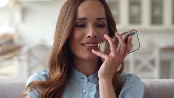 笑顔のビジネス女性は自宅のオフィスで電話を話しています。音声メッセージの録音 - 映像、動画