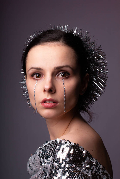 beautiful girl in a best-looking dress, a brilliant rim with rhinestones on her face - Foto, Imagen