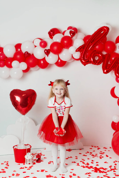 Saint Valentin - portrait d'une jolie petite fille dans un studio décoré. Belle petite fille habillée en Cupidon
 - Photo, image