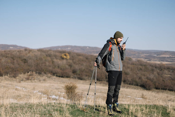 Man standing on a hill and talking on walkie-talkie - Valokuva, kuva