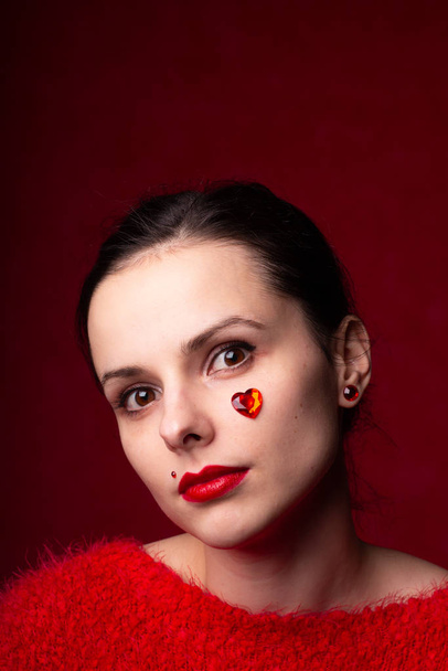 girl in red with a heart on her cheek - Φωτογραφία, εικόνα
