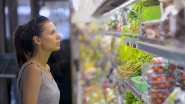 woman choosing lettuce in organic vegetables department refrigerator. buying heathy vegetarian food - 映像、動画