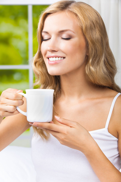 Young woman drinking coffee or tea, at home - Foto, Imagem