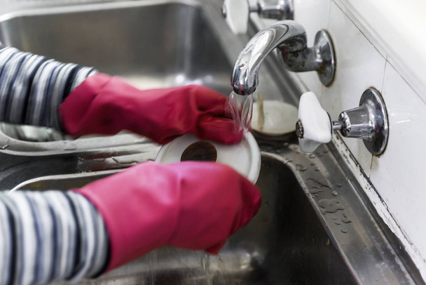 女性はピンクの手袋で食器洗い機を手 - 写真・画像