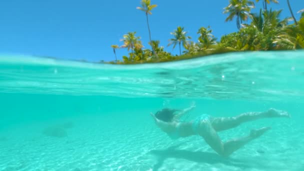Slow Motion: Szczęśliwa turystka nurkująca wokół rajskiej plaży. - Materiał filmowy, wideo
