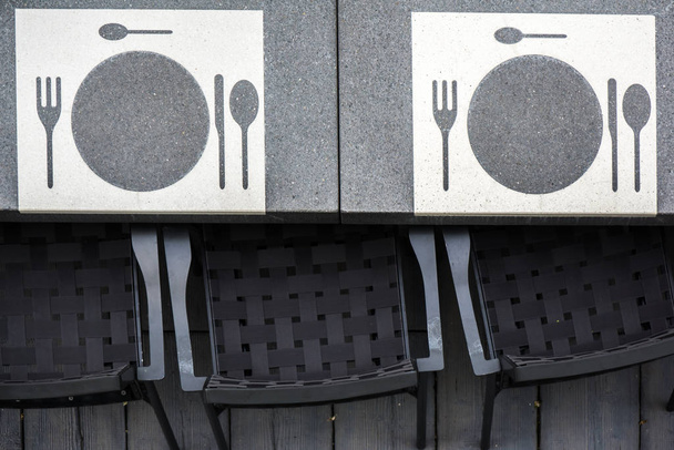 бетонный стол с посудой и стулом - Фото, изображение
