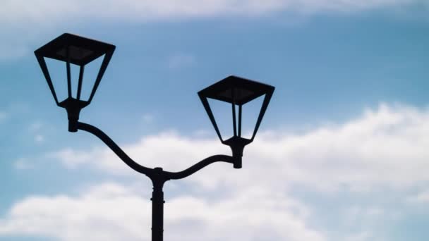 Luz de calle se mantiene encendida en las nubes azules en movimiento
 - Metraje, vídeo
