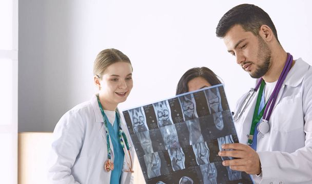 Лікар дивиться рентгенівську фотографію літньої жінки
 - Фото, зображення