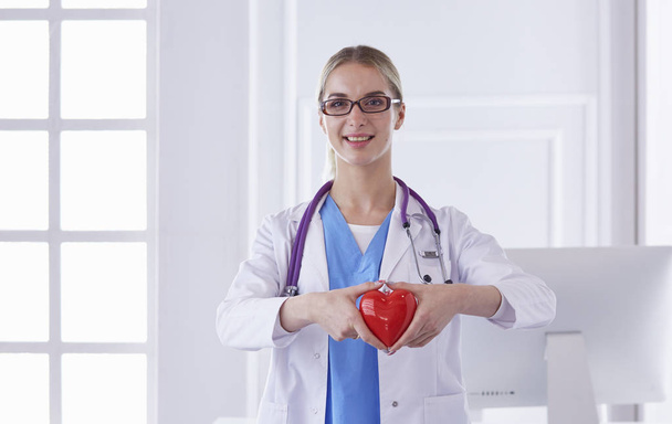 Doctor with stethoscope holding heart, isolated on white background - Photo, Image