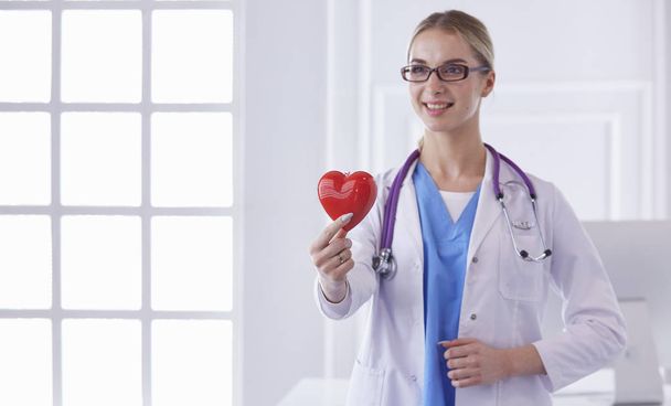 Доктор зі стетоскопом, що тримає серце, ізольовано на білому тлі
 - Фото, зображення
