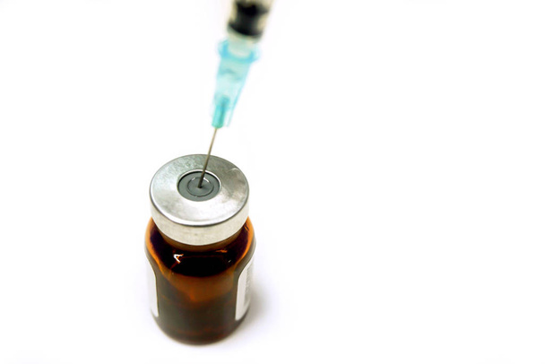 La vacuna en el frasco del vial de medicamento ya se ha abierto se preparan para inyección al paciente en un fondo blanco
. - Foto, imagen