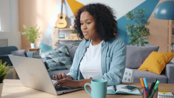 Excited African American business lady enjoying success at freelance work at home - Filmati, video