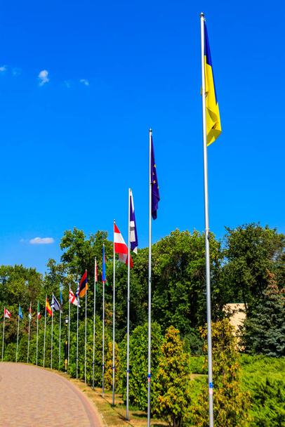Flags of different countries on high flagpoles in park - Photo, Image