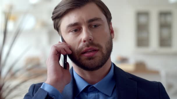 Attractive business man making phone call at home. Guy talking on cellphone - Imágenes, Vídeo