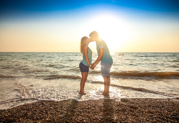 Casal apaixonado de pé na água e beijando
 - Foto, Imagem
