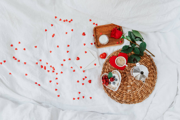 Valentines day breakfast with muesli, coffee and red rose on bed. Flat lay, top view, heart shape love concept valentines day - Foto, Bild