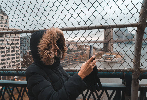 Touristin mit warmer Kleidung auf der Manhattan-Brücke - Foto, Bild