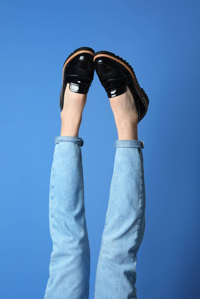 Woman wearing stylish shoes on blue background, closeup - Фото, изображение