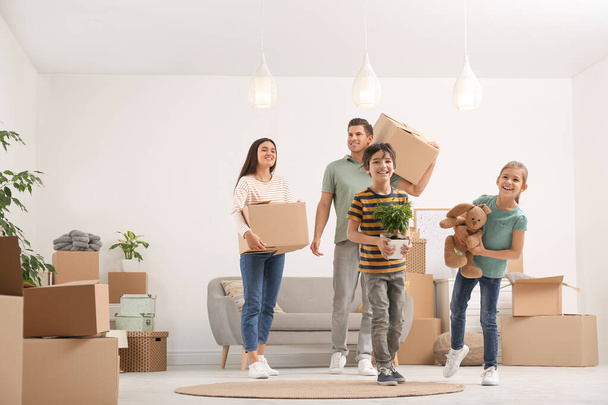 Happy family in room with cardboard boxes on moving day - Photo, image