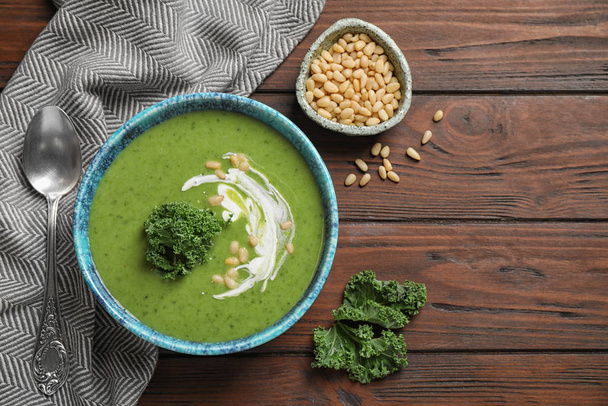 Tasty kale soup served on wooden table, flat lay - Foto, immagini