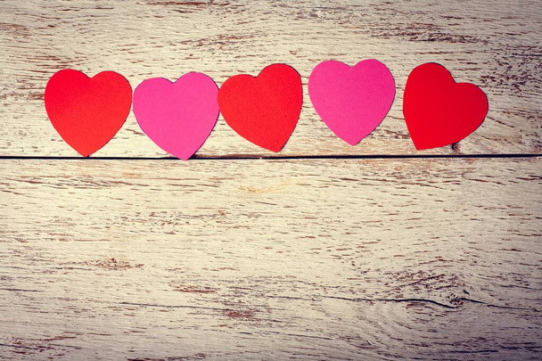 Gekleurde papieren hartjes op een houten achtergrond. Vakantie. Valentijnsdag. - Foto, afbeelding