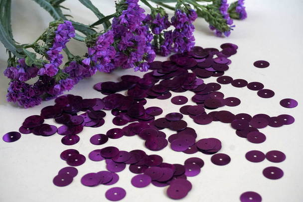 Detail fialových kulatých flitrů a fialových sušených květů. - Fotografie, Obrázek
