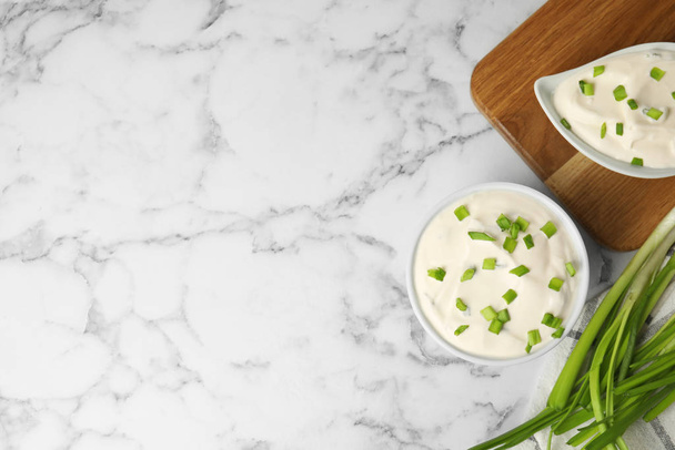 Fresh sour cream with onion on white marble table, flat lay. Space for text - Fotoğraf, Görsel