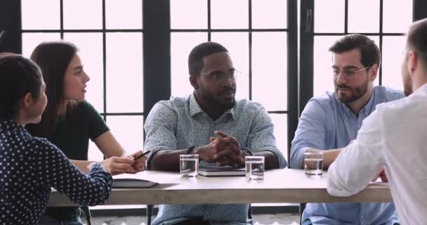 アフリカの男性指導者企業のワークショップオフィステーブルに座る - 映像、動画