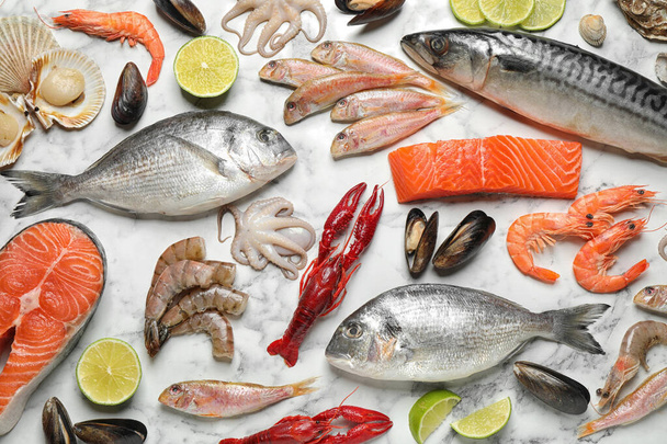 Świeże ryby i różne owoce morza na białym marmurowym stole, płaskie leżaki - Zdjęcie, obraz
