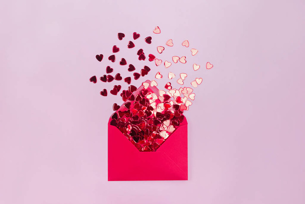 The Concept Of Valentines Day. Love letter. Envelope and flying out of it red hearts on a red background. - Photo, image