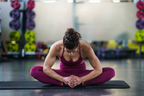 Молода жінка робить вправи на йога килимок
 - Фото, зображення