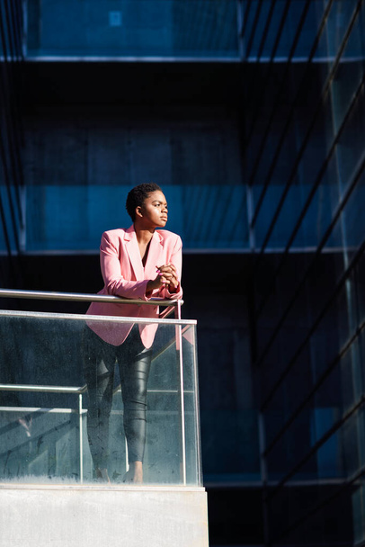 Femme d'affaires africaine debout près de l'immeuble de bureaux d'affaires
. - Photo, image
