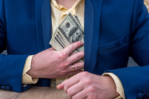 Üzletember elrejti dollár bankjegyek zsebbe - Fotó, kép