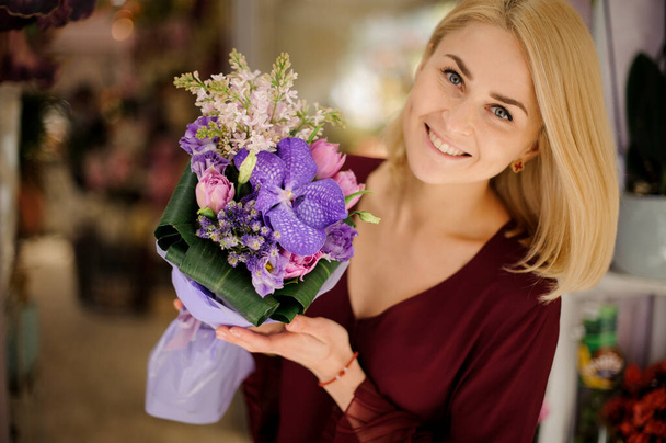 Smiling woman with a bouquet with iris - Photo, Image