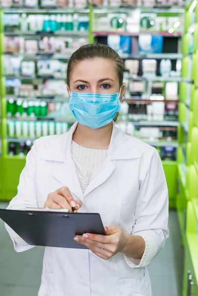 Woman chemist checking medication list in drugstore - Фото, изображение