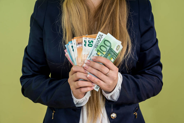 woman holding euro banknotes isolated on green - Photo, Image