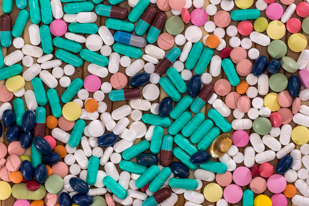 Colourful tablets dispersed on wooden table closeup - Photo, Image