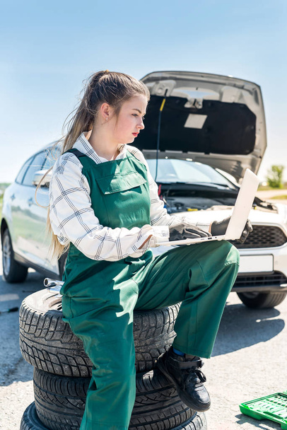 Mechanic with laptop diagnosing broken car on roadside - Photo, Image