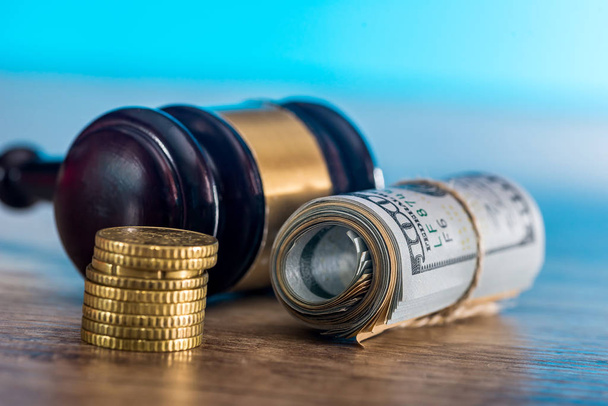 Martelo do juiz com dólares em rolo e moedas de ouro
 - Foto, Imagem