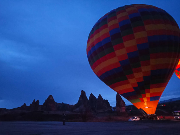 Colorful Hot Air Balloons flying over Cappadocia early morning at winter with dark morning in Turkey - Фото, зображення