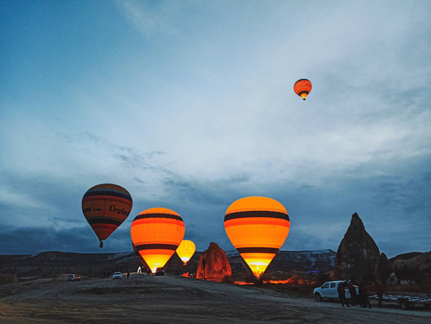 Colorful Hot Air Balloons flying over Cappadocia early morning at winter with dark morning in Turkey - Fotografie, Obrázek