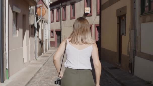 Mujer joven se ejecuta en la vieja calle mirando hacia atrás en la cámara
 - Imágenes, Vídeo